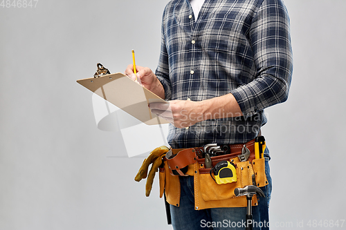 Image of builder with clipboard, pencil and working tools