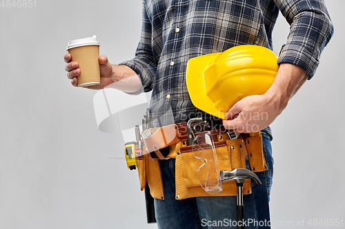 Image of male builder with coffee, helmet and working tools