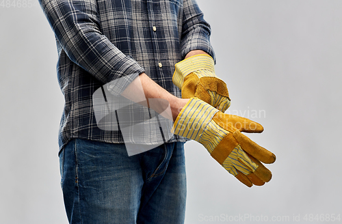 Image of man or builder putting protective gloves on