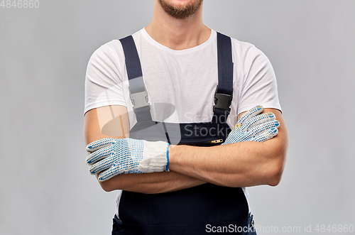 Image of close up of male builder in overall and gloves