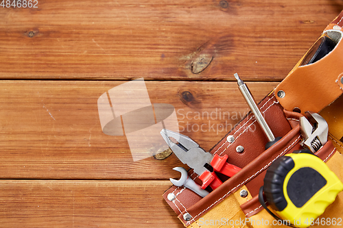 Image of different work tools in belt on wooden boards