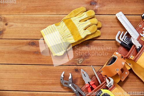 Image of different work tools in belt on wooden boards