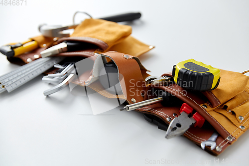 Image of different work tools in belt on white background