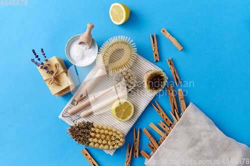 Image of cleaning brushes, lemon and wooden clothespins