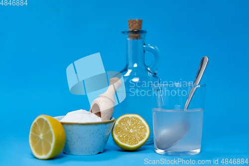 Image of lemons, washing soda, bottle of vinegar and glass