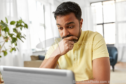 Image of indian man with laptop working at home office