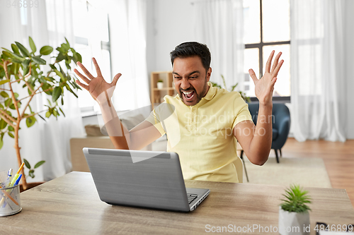 Image of indian man with laptop working at home office