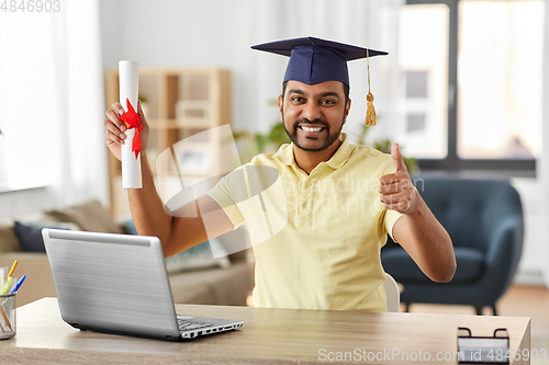 Image of indian student with laptop and diploma at home