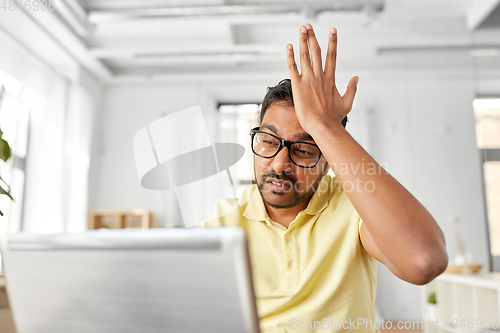 Image of stressed man with laptop working at home office