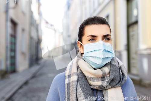 Image of woman wearing protective medical mask in city