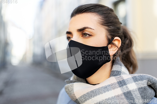 Image of woman wearing protective reusable mask in city