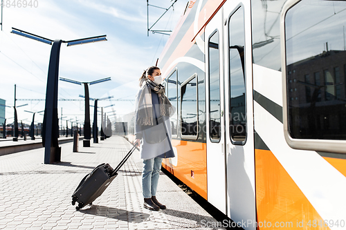 Image of woman in protective face mask at railway station