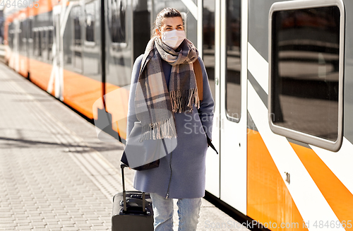 Image of woman in protective face mask at railway station