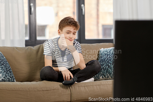 Image of sad boy with gamepad playing video game at home