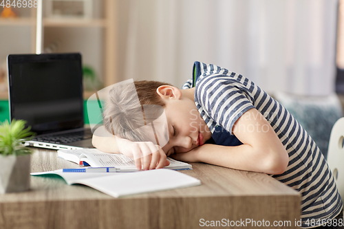 Image of tired student boy sleeping on desk at home