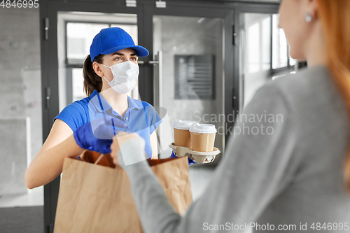 Image of delivery girl in mask giving paper bag to customer