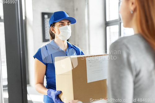 Image of delivery girl in face mask giving parcel to woman