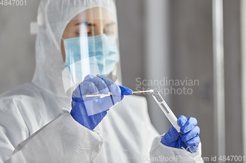 Image of scientist holding beaker with coronavirus test