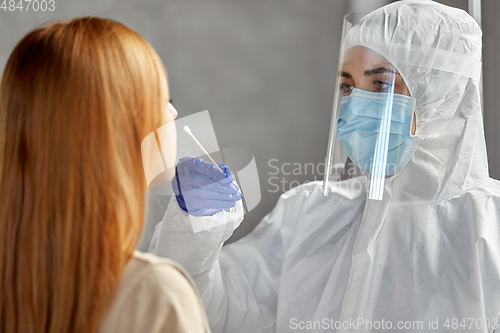 Image of doctor in protective wear making coronavirus test