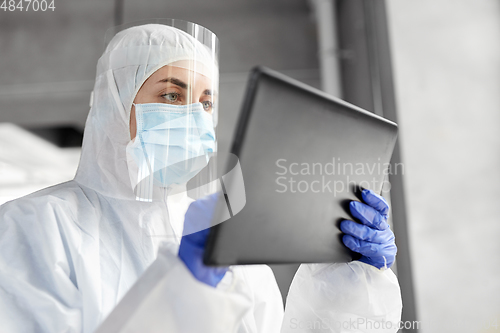 Image of doctor in protective wear with tablet computer