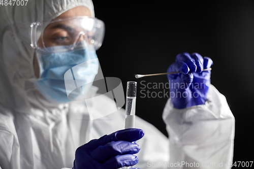 Image of scientist holding beaker with coronavirus test