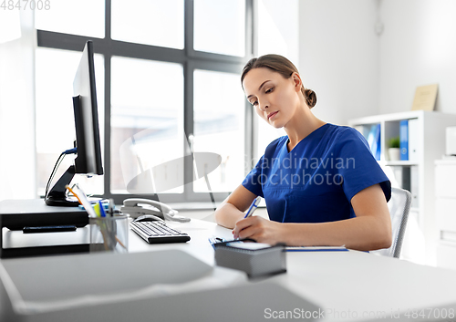 Image of doctor or nurse with clipboard working at hospital