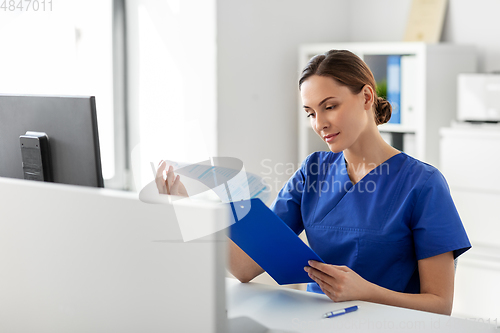 Image of doctor or nurse with clipboard working at hospital