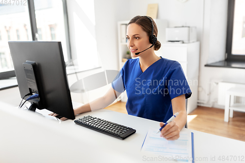 Image of doctor with headset and computer at hospital