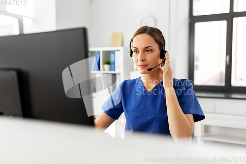 Image of doctor with headset and computer at hospital