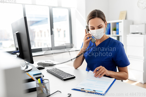 Image of doctor with computer calling on phone at hospital