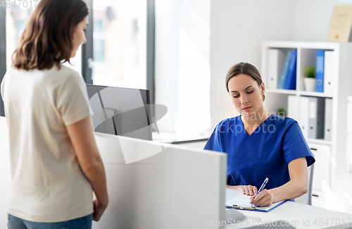 Image of doctor with clipboard and patient at hospital