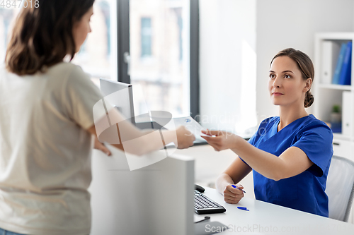 Image of doctor and patient with prescription at hospital