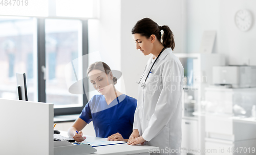 Image of doctor and nurse with clipboard at hospital