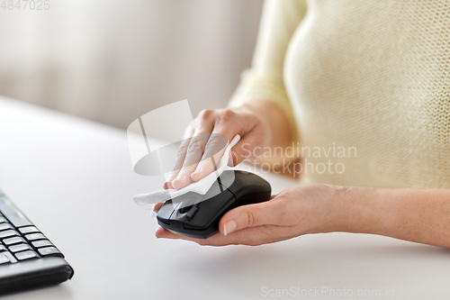 Image of close up of woman cleaning computer mouse