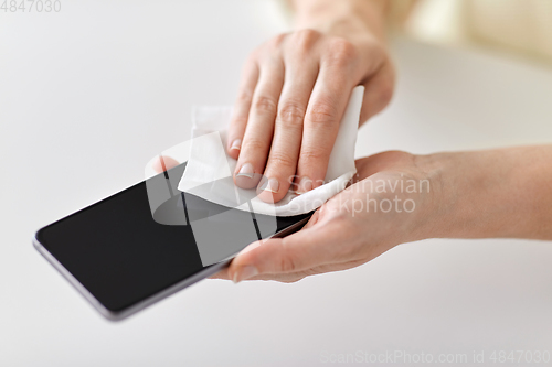 Image of close up of hands cleaning smartphone with tissue