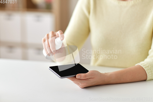 Image of close up of woman hands cleaning smartphone