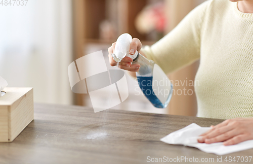 Image of close up of woman cleaning table at home