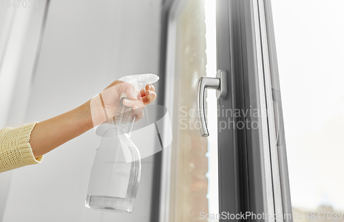 Image of hands cleaning window handle with detergent