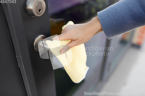 Image of hand cleaning door handle with microfiber rag