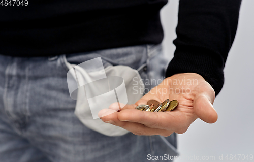Image of close up of man showing coins and empty pockets