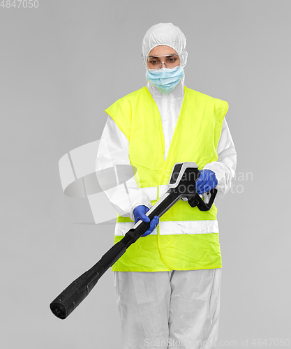 Image of sanitation worker in hazmat with pressure washer