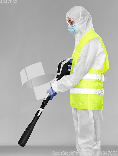 Image of sanitation worker in hazmat with pressure washer