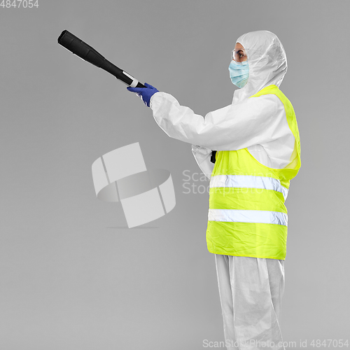 Image of sanitation worker in hazmat with pressure washer