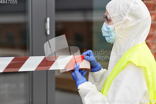 Image of healthcare worker sealing door with caution tape