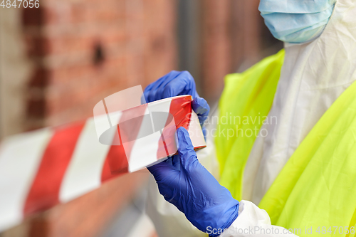 Image of healthcare worker sealing door with caution tape