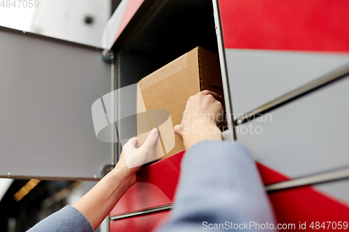 Image of woman putting box to automated parcel machine