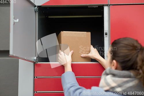 Image of woman putting box to automated parcel machine