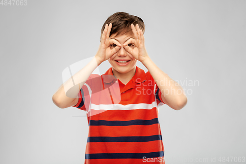 Image of happy smiling boy looking through finger glasses