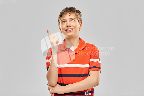Image of portrait of happy smiling boy pointing finger up