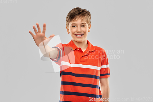 Image of portrait of happy smiling boy showing five fingers